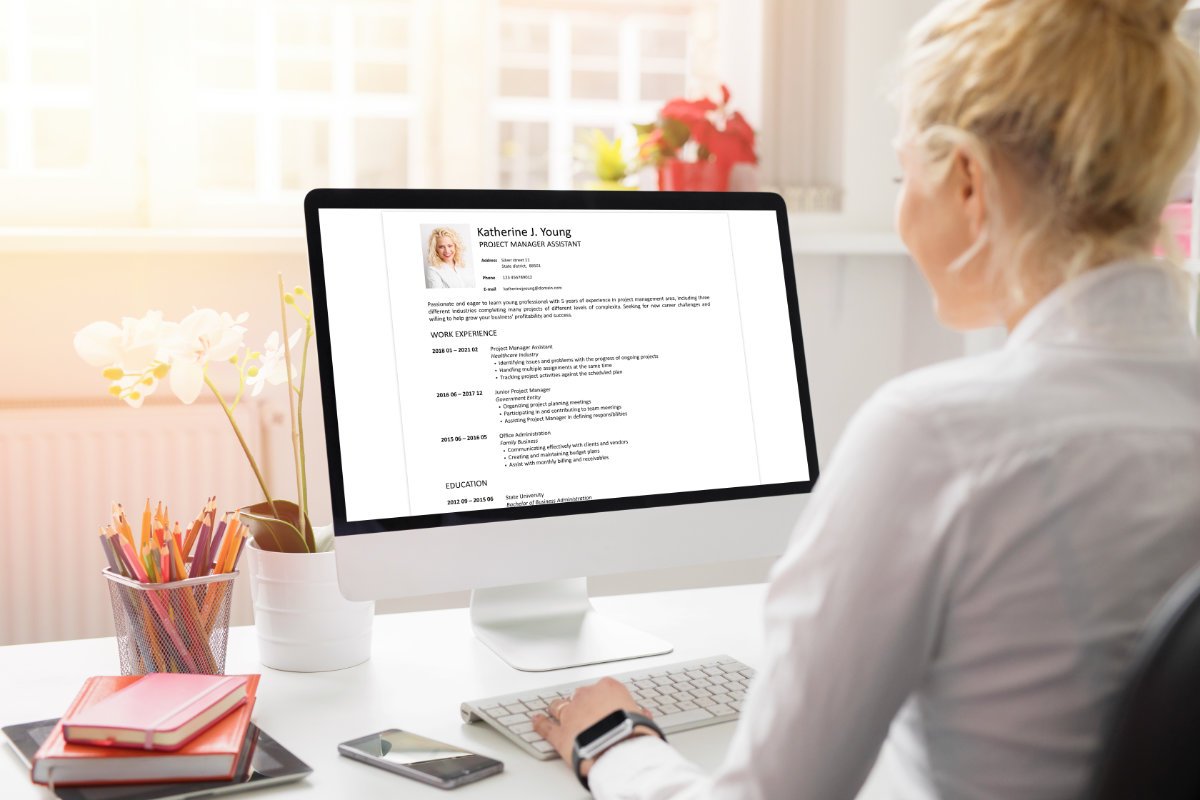 A professional reviewing a CV on a computer screen.